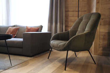 A stylish vacation apartment in Andermatt in Switzerland with modern gray furniture, coffee table and cozy atmosphere.