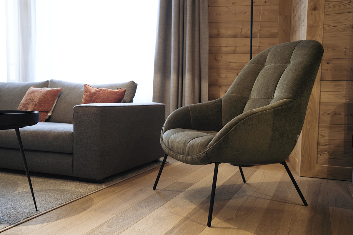 A stylish vacation apartment in Andermatt in Switzerland with modern gray furniture, coffee table and cozy atmosphere.