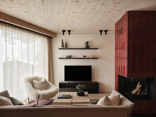 cozy living room with fireplace and snow mountain to be seen through the window