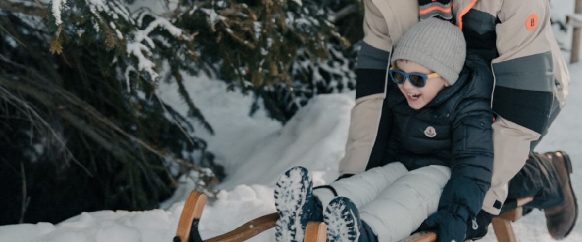 father and son on a sledding in the snow