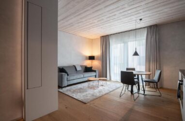 studio with dining table, sofa and wooden parquet