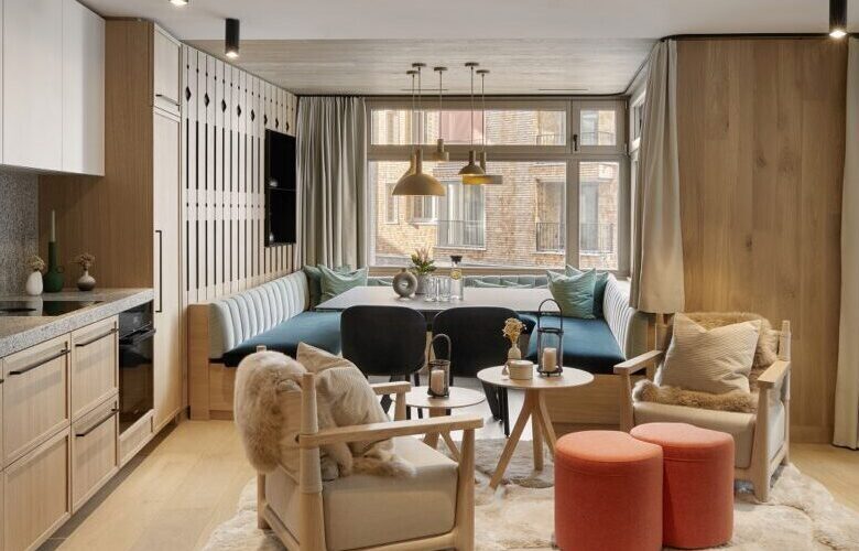 kitchen and dining room with U shape table beige lounge chairs and orange pouf